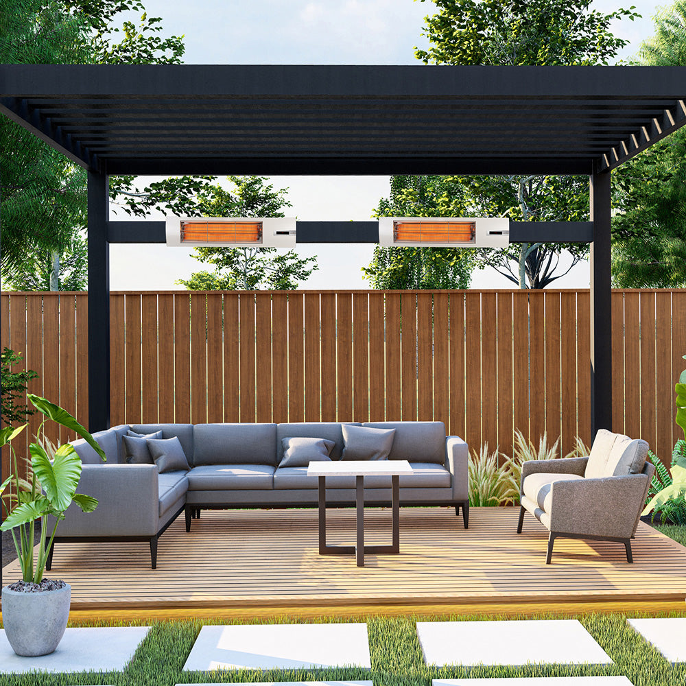 Outdoor patio with gray sectional sofa, chair, and table under a black pergola with white infrared heaters.