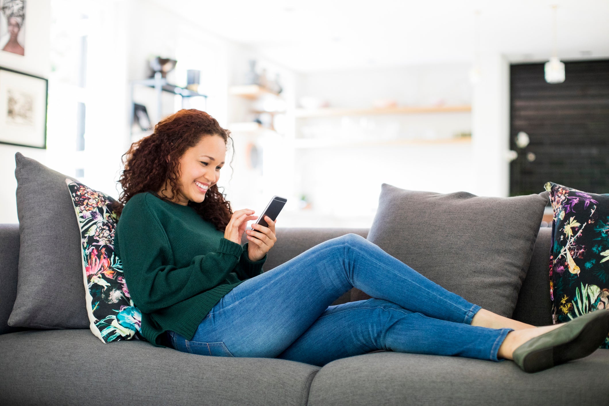 Woman sitting on the couch using her phone