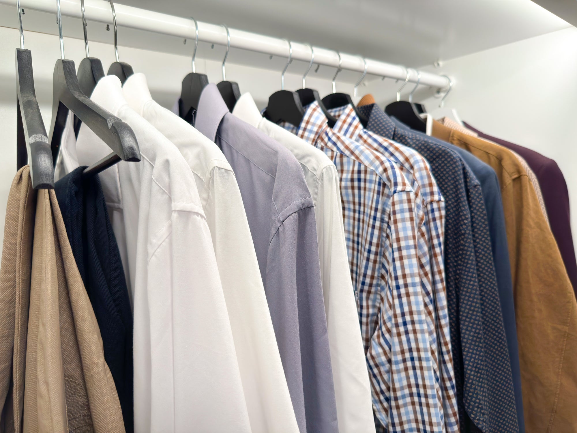 Men's clothing hanging in a closet.