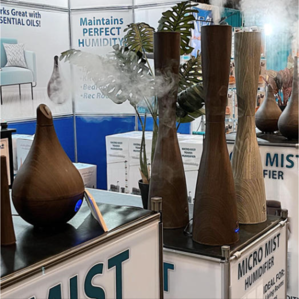 Display of wooden humidifiers releasing mist in a product showcase, with a sign highlighting "Micro Mist Humidifier."