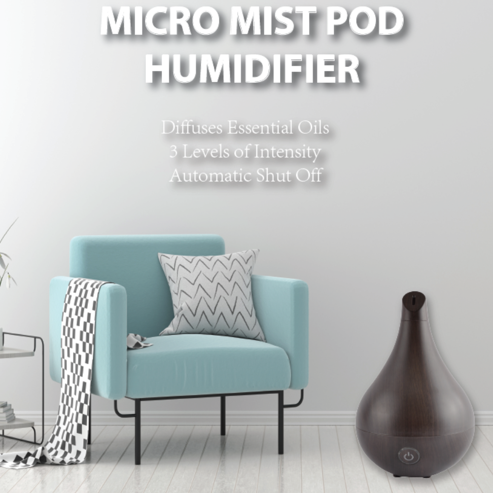A cozy room featuring a light blue chair, a patterned pillow, a black and white throw, and a Micro Mist Pod Humidifier & Essential Oil Diffuser in Dark Wood.