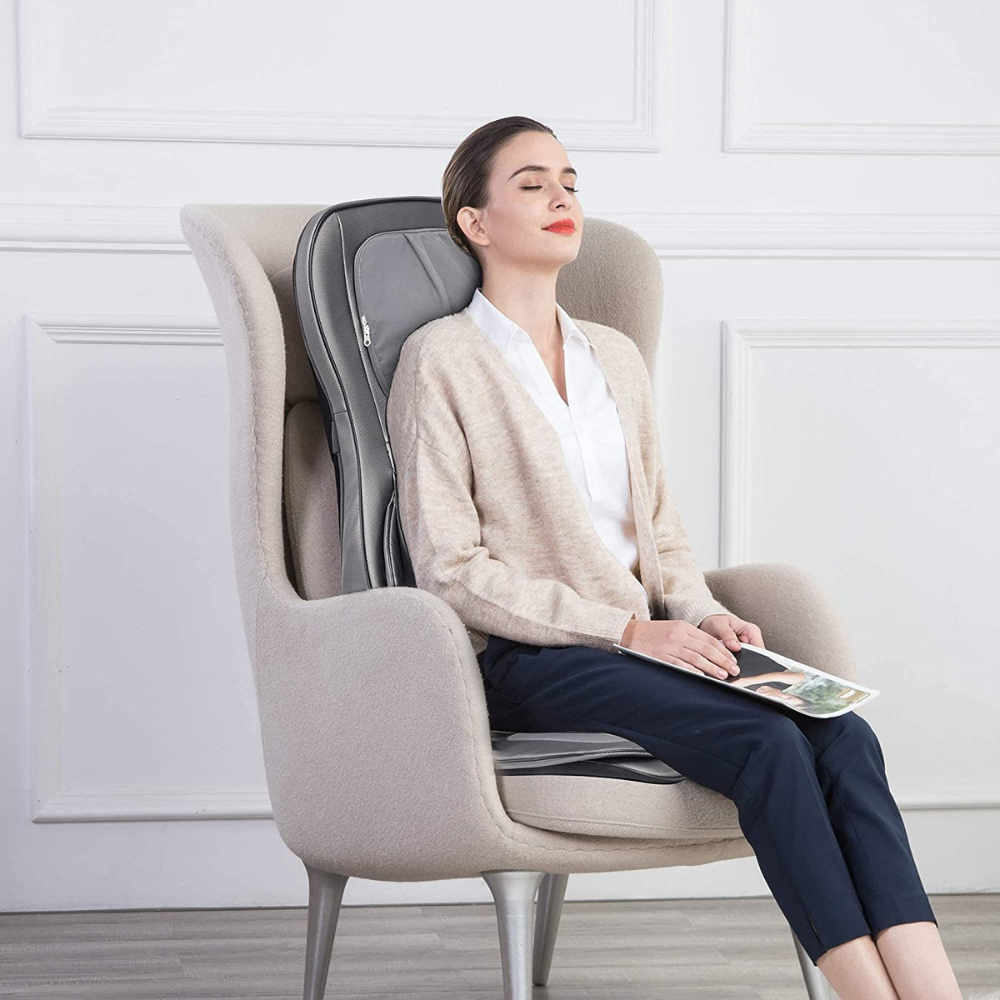 Woman sitting on chair using the BACKplus® Shiatsu Neck and Back Massager With Air Compression Chair Cushion