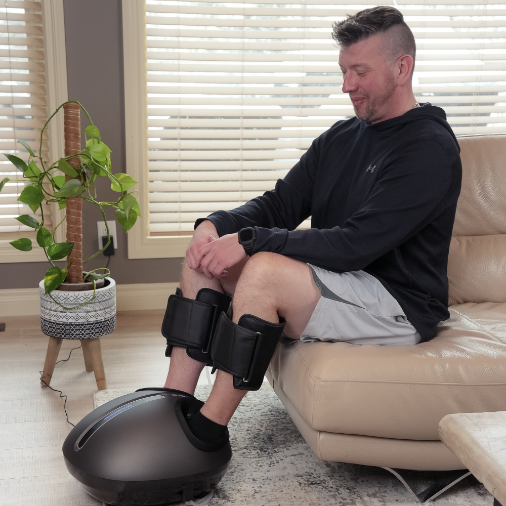 A man on a beige couch with a Backplus Shiatsu Foot Massager