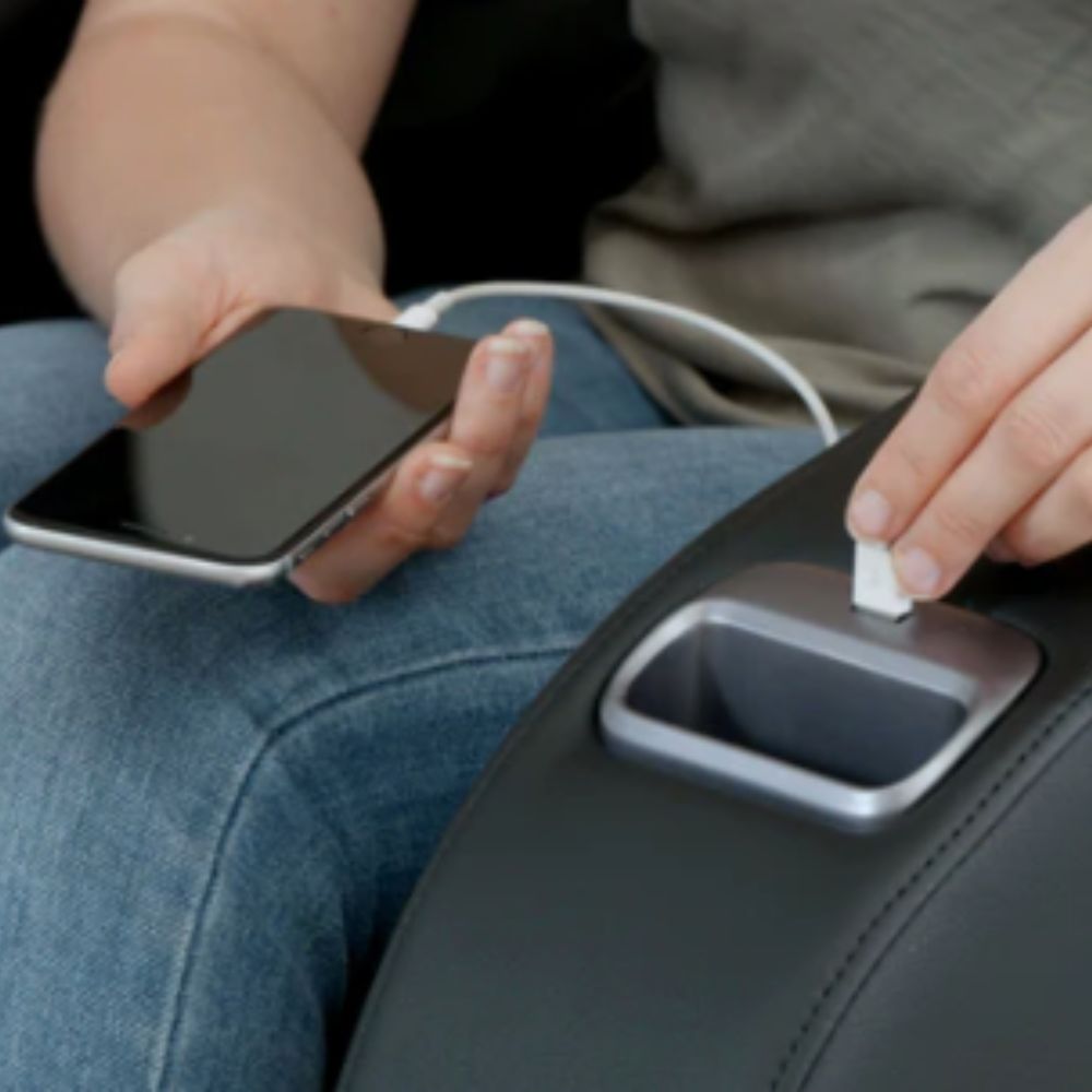 Person holding a smartphone charging it with massage chair