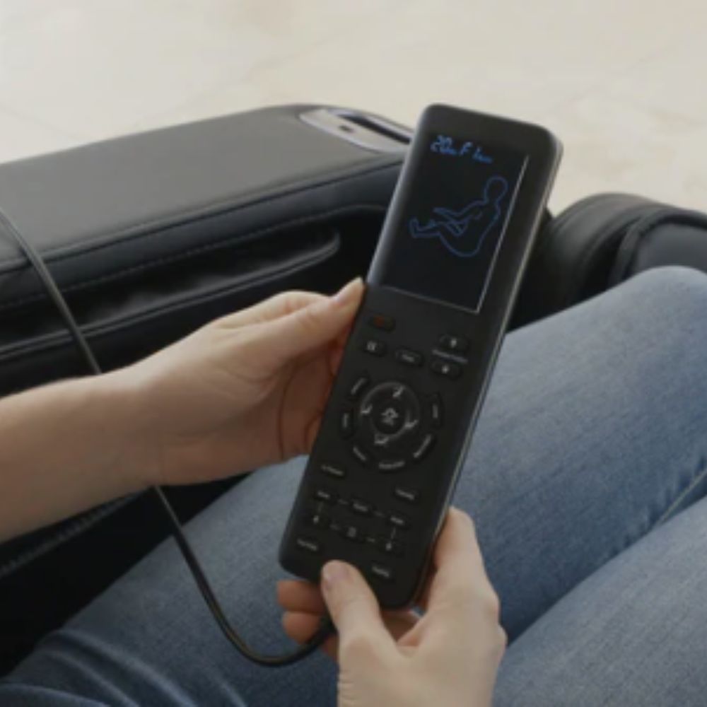 Person holding a black remote control with blue graphics on a light background