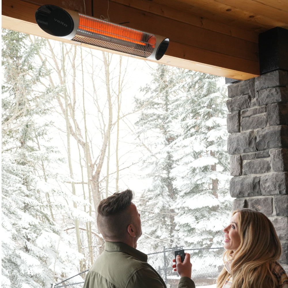 A couple looking at their Veito® Blade 1500W infrared Heater installed on the wall.