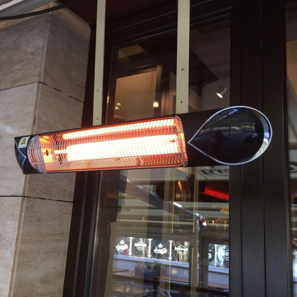 A mounted infrared heater emitting a warm glow, positioned near glass doors in a restaurant setting.