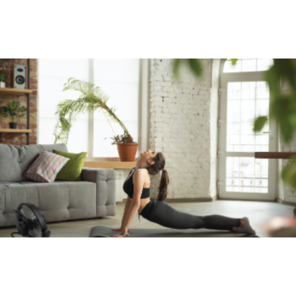 iQ Rechargeable Floor Fan being used by woman doing yoga