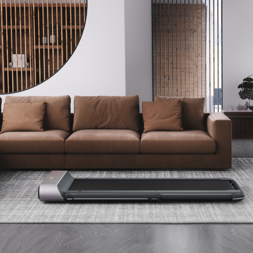 iQ Slim Tread® Foldable Treadmill - Professional Model sitting in front of couch