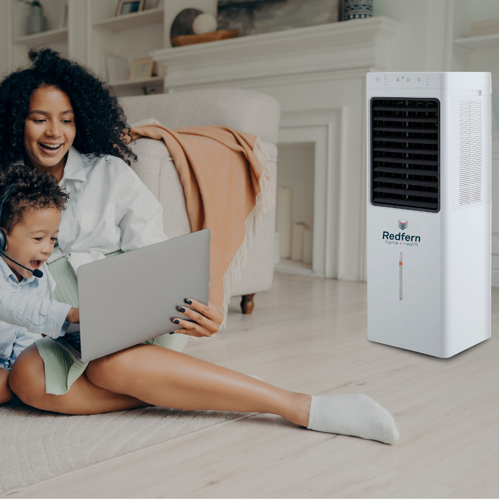 iQ Pure Breeze EXTRA Large Air Cooler being used by a mother and son while they use a laptop.