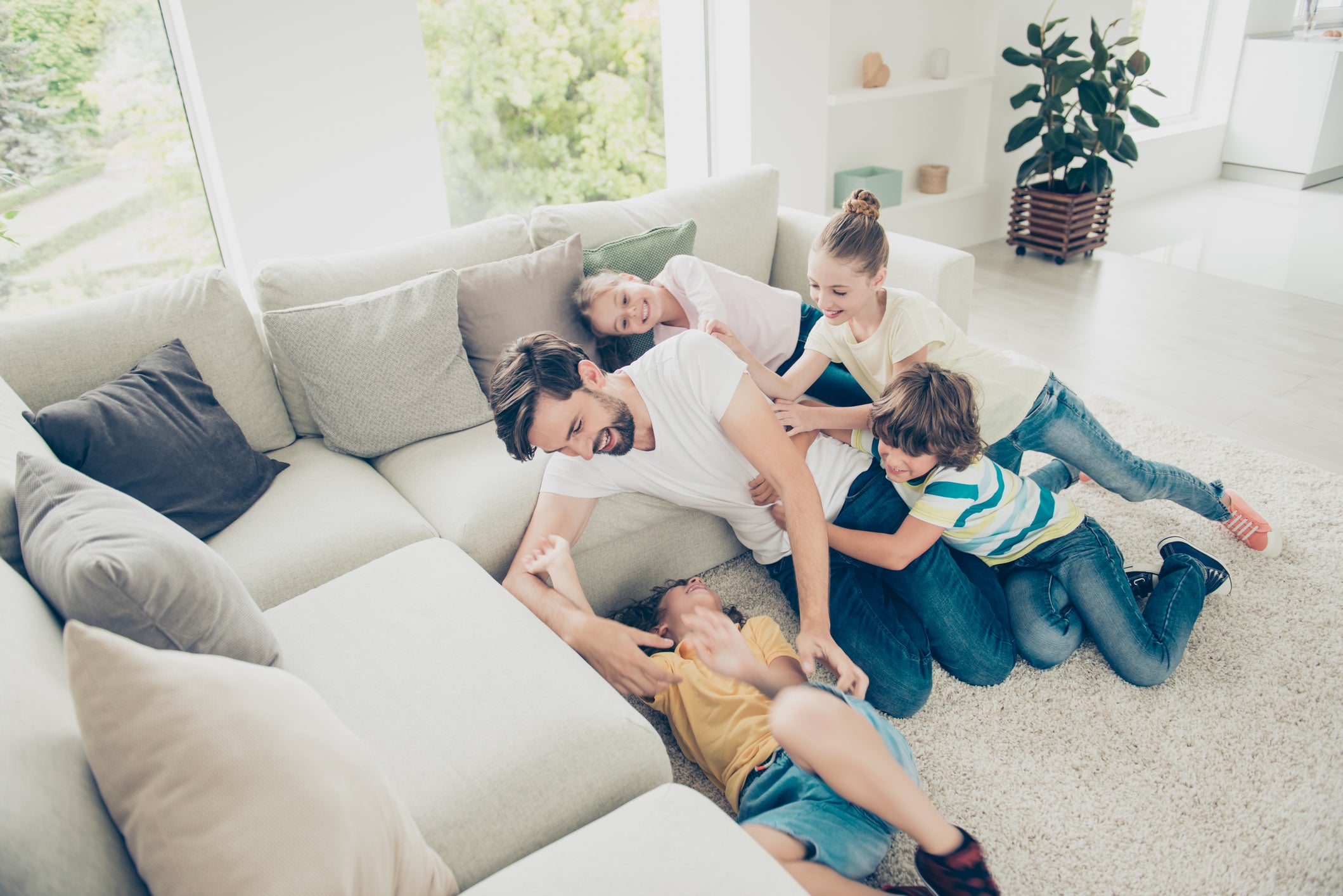 Father and children playing in the living room.