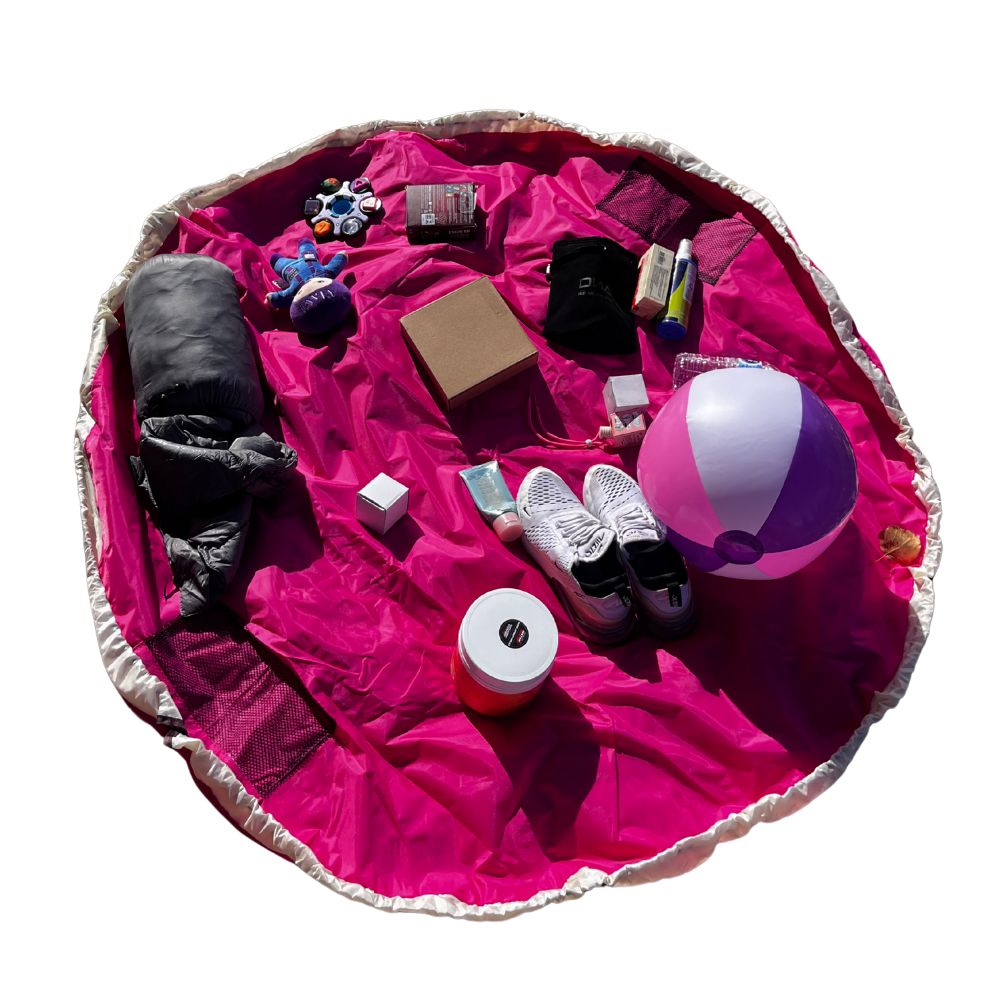 Pink Nifty Sac Toy Organizer with various items including a beach ball and shoes on a white background