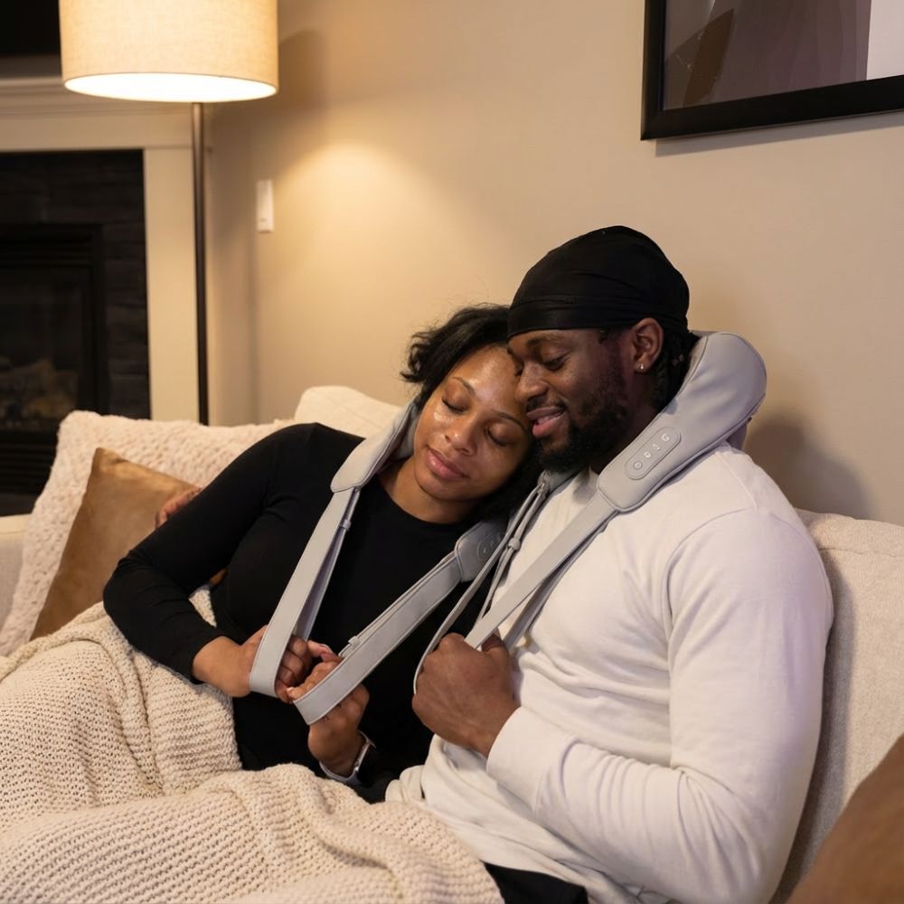 Two people using a neck and shoulder massager in a cozy living room.