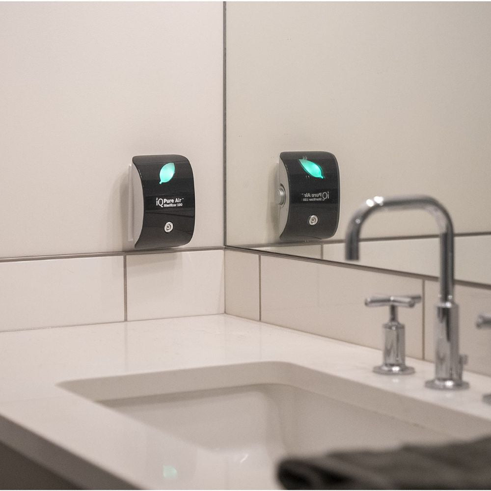 Air purifier on a wall next to a sink in a bathroom setting