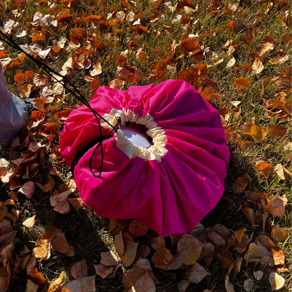 Pink Nifty Sac on a grassy area with fallen leaves