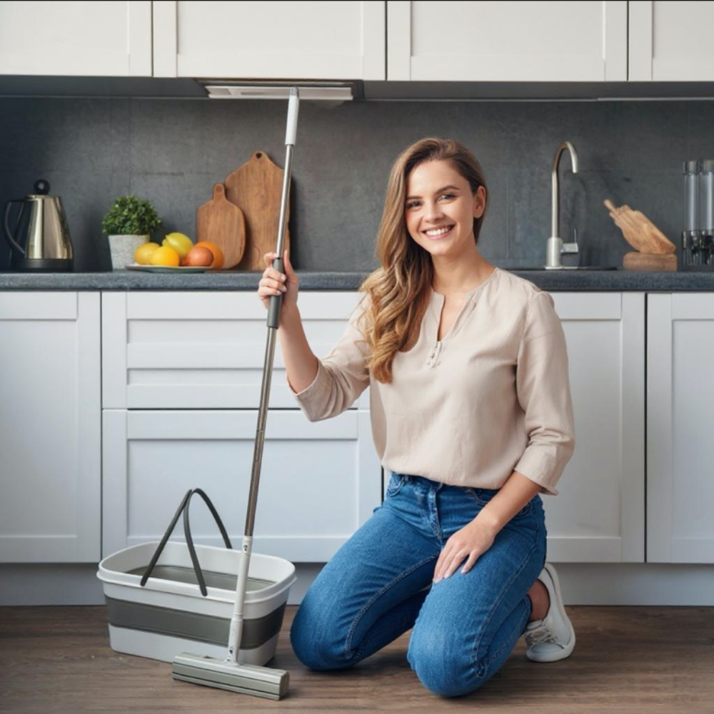 Woman cleaning a kitchen floor with a mop and bucket. Rocket Mop PVA set designed for efficient wet and dry cleaning.