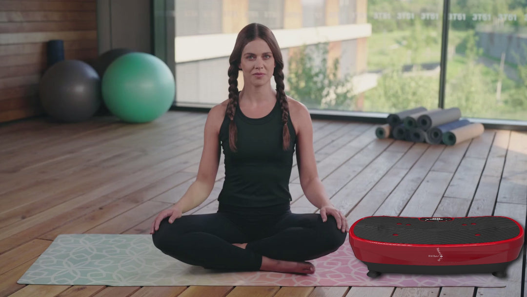 Woman sites in home gym in front of a Backplus Pro Fitness Board. Vibration board with multi-speed settings and built‑in LED display